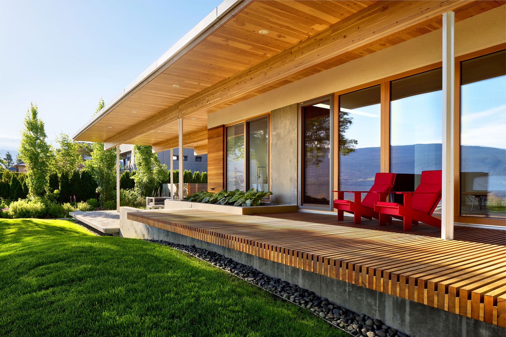 Detail exterior view of modern residence with wood slatted decking and lawn