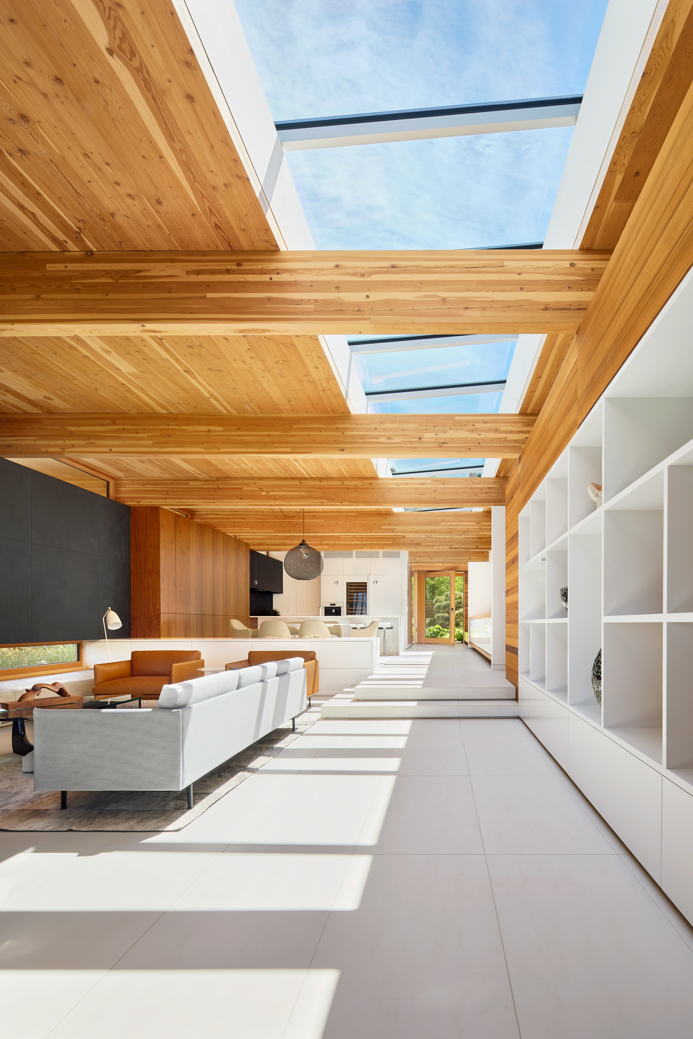 Interior view of modern bright home with blue skylights and view out front door