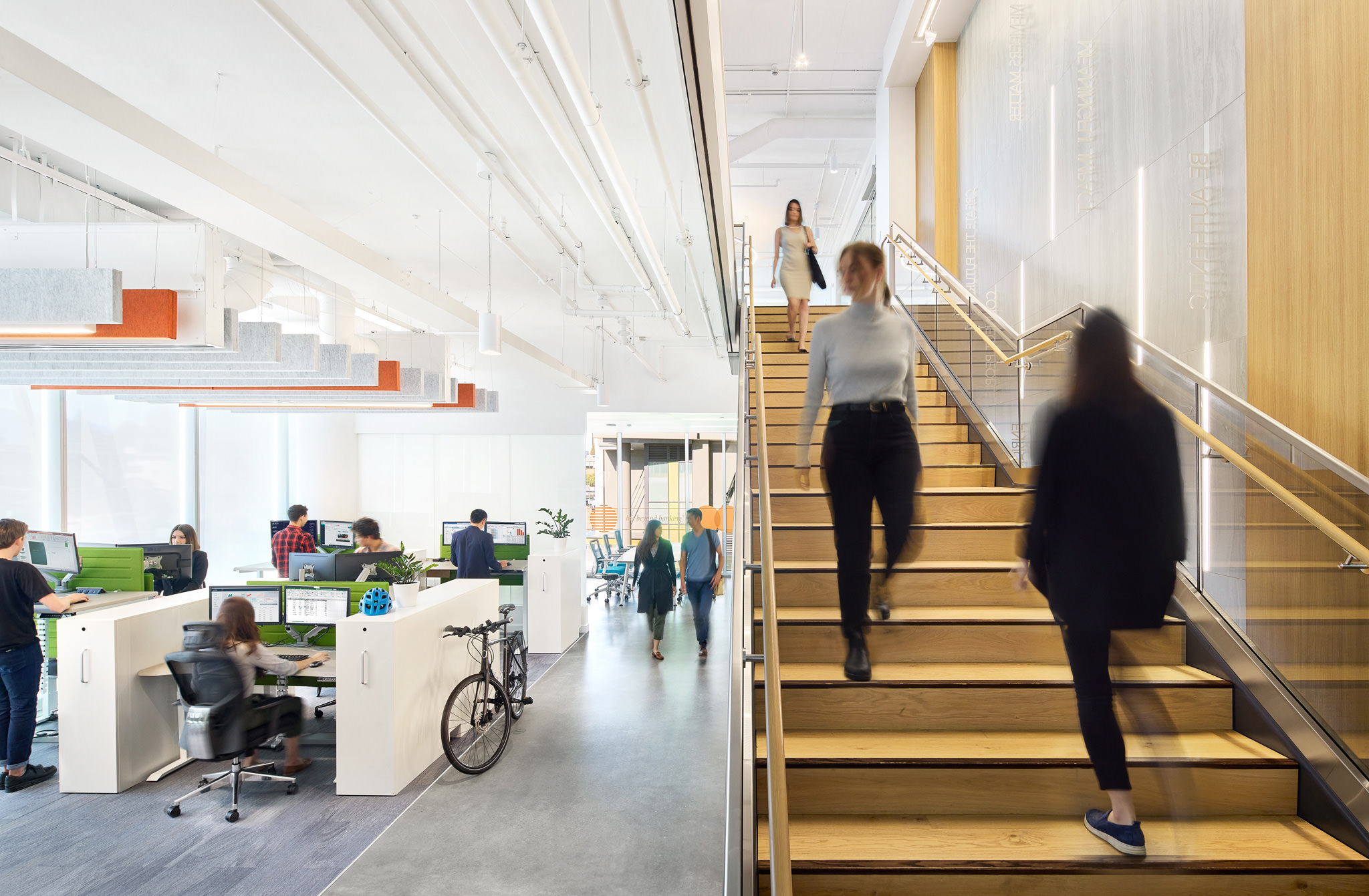 Employees Moving Through Bright Modern Office And Staircase