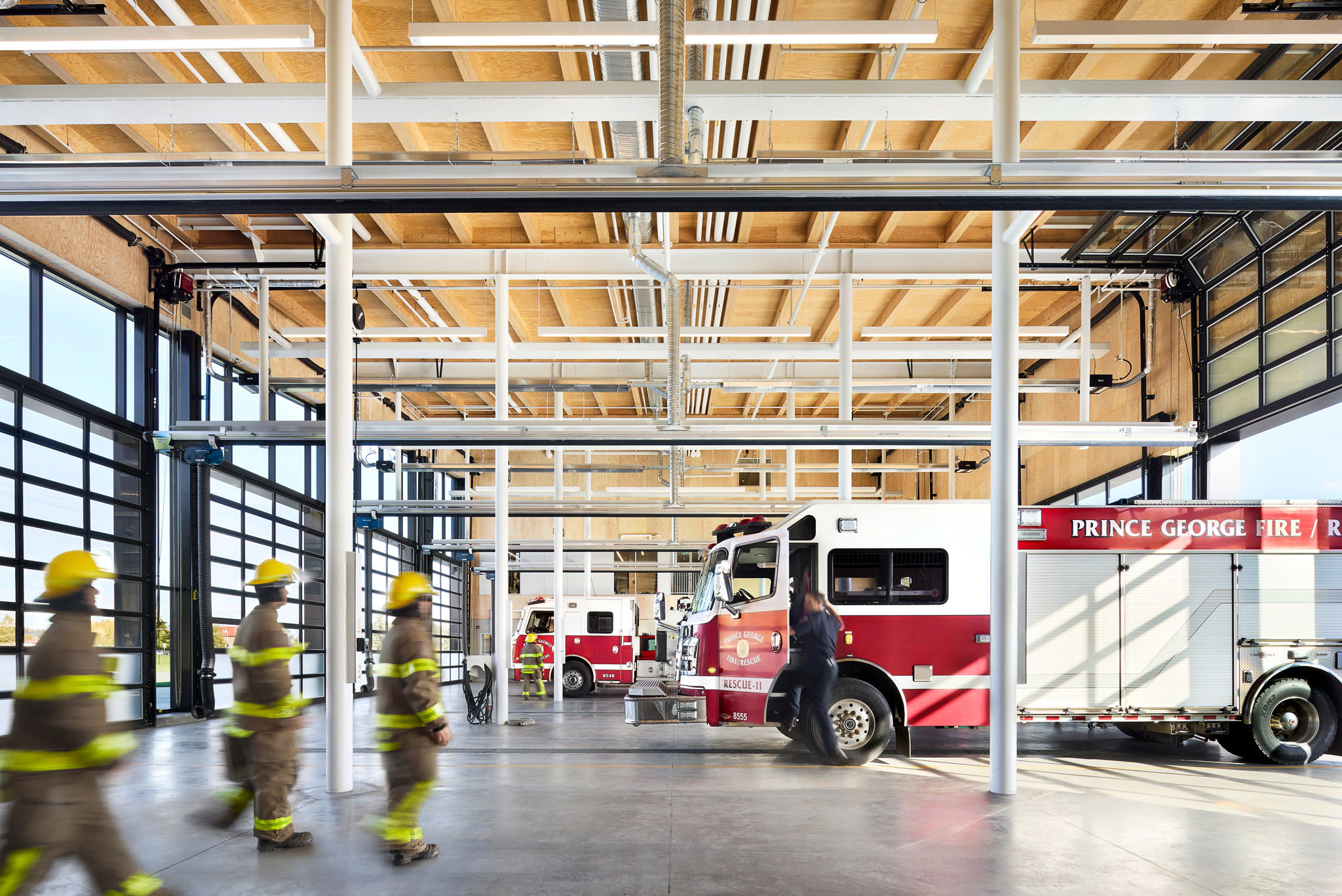 Modern Firehall Garage With Fire Engines And Firefighters